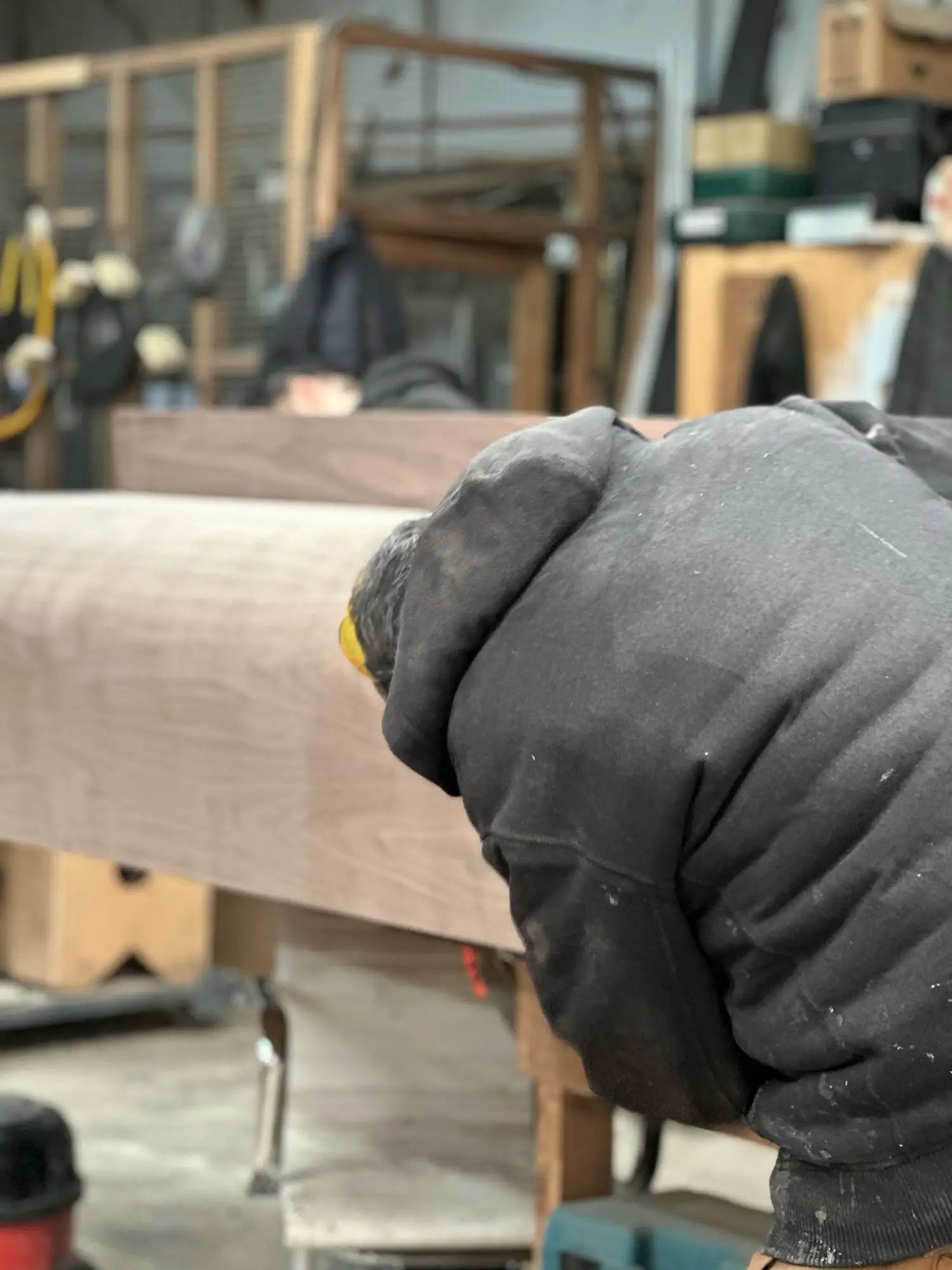 Craftsman hand-finishing a solid walnut column in Studio Tuesday’s London workshop